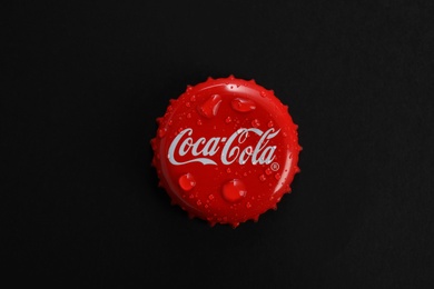 MYKOLAIV, UKRAINE - NOVEMBER 15, 2018: Coca Cola lid on black background, top view