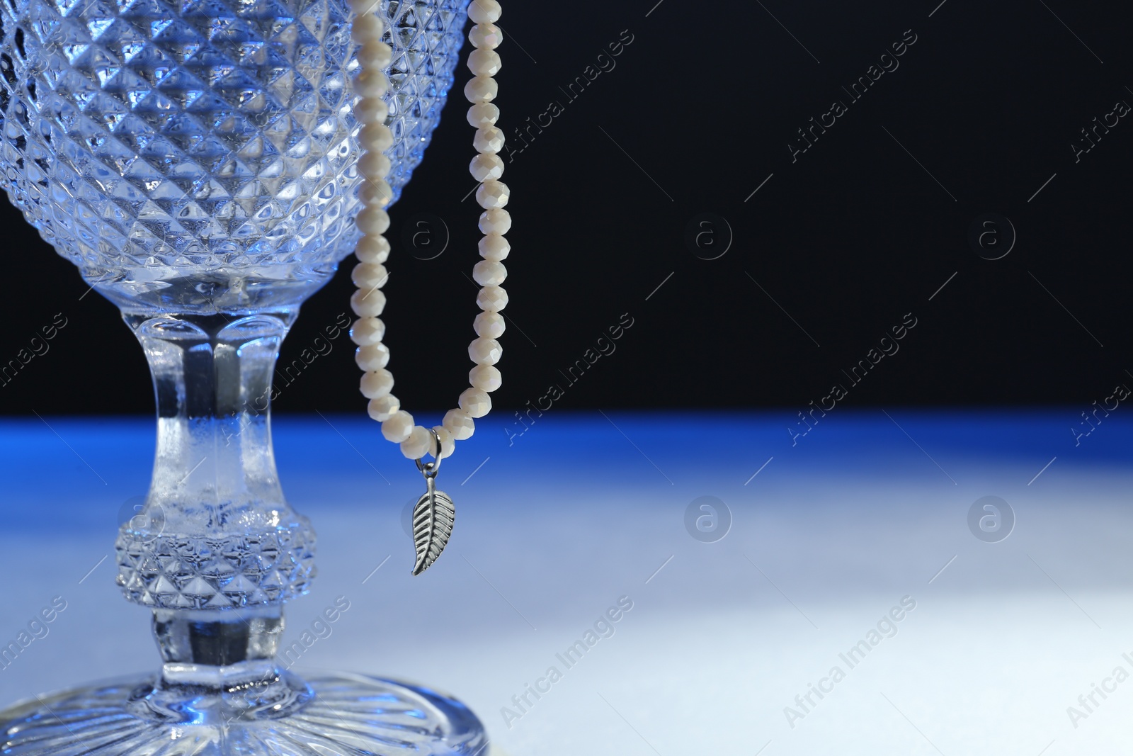 Photo of Stylish presentation of elegant pearl necklace on table. Space for text