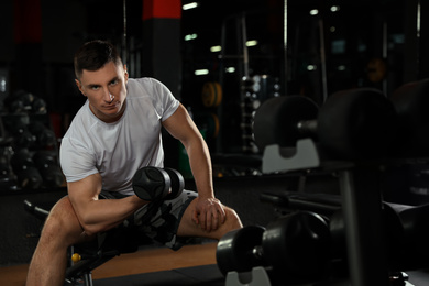 Man working out with dumbbell in modern gym