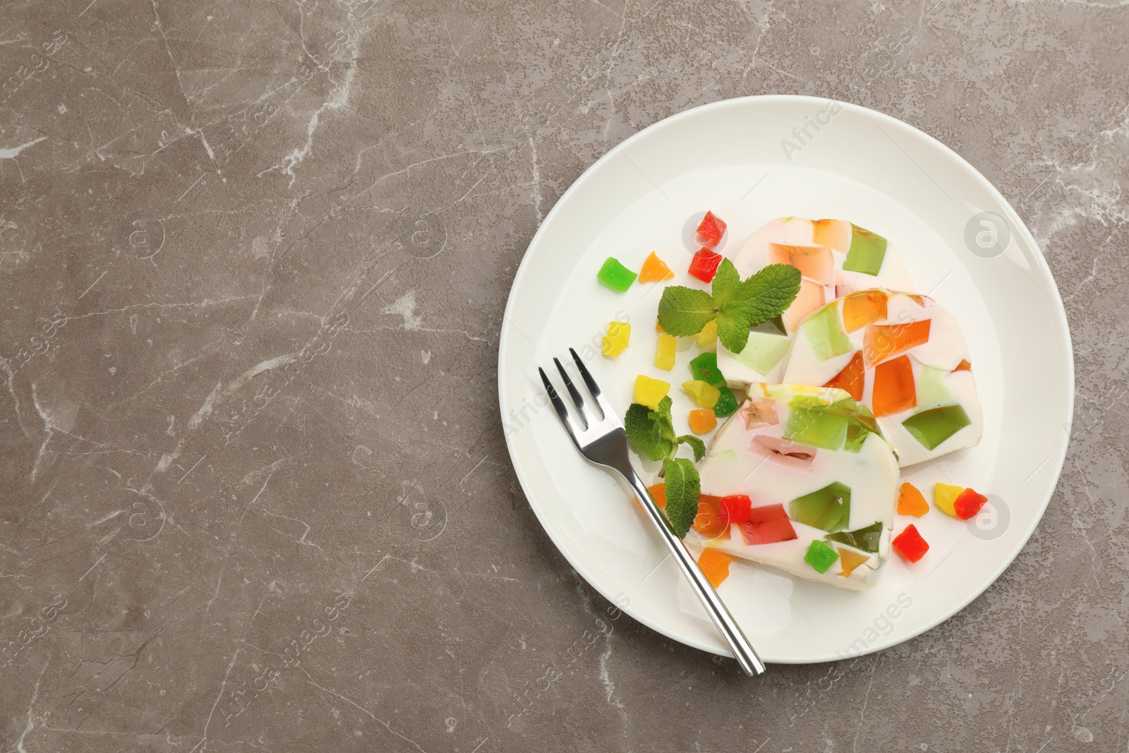 Photo of Delicious broken glass jelly dessert on table, top view. Space for text