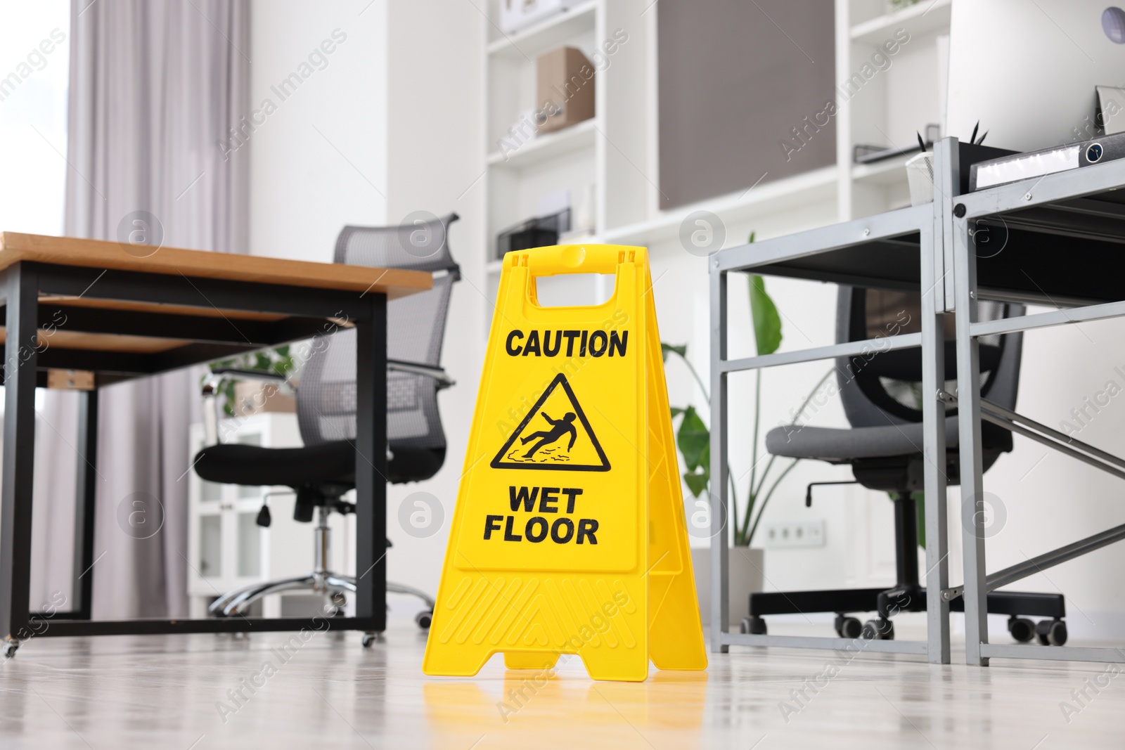 Photo of Cleaning service. Wet floor sign in office