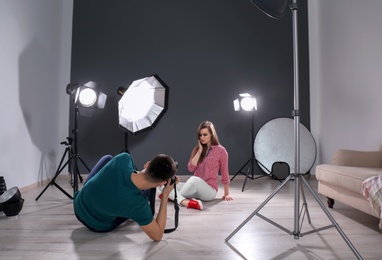 Beautiful young model posing for professional photographer in studio