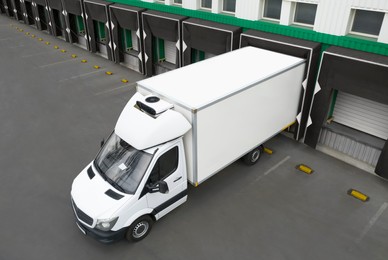 Image of Truck near loading dock of warehouse outdoors, aerial view. Logistics center