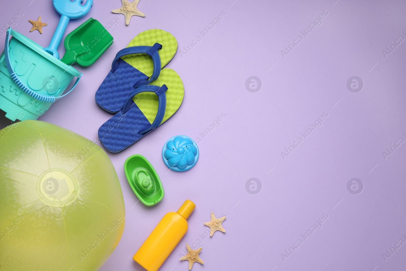 Photo of Flat lay composition with beach ball and sand toys on violet background. Space for text