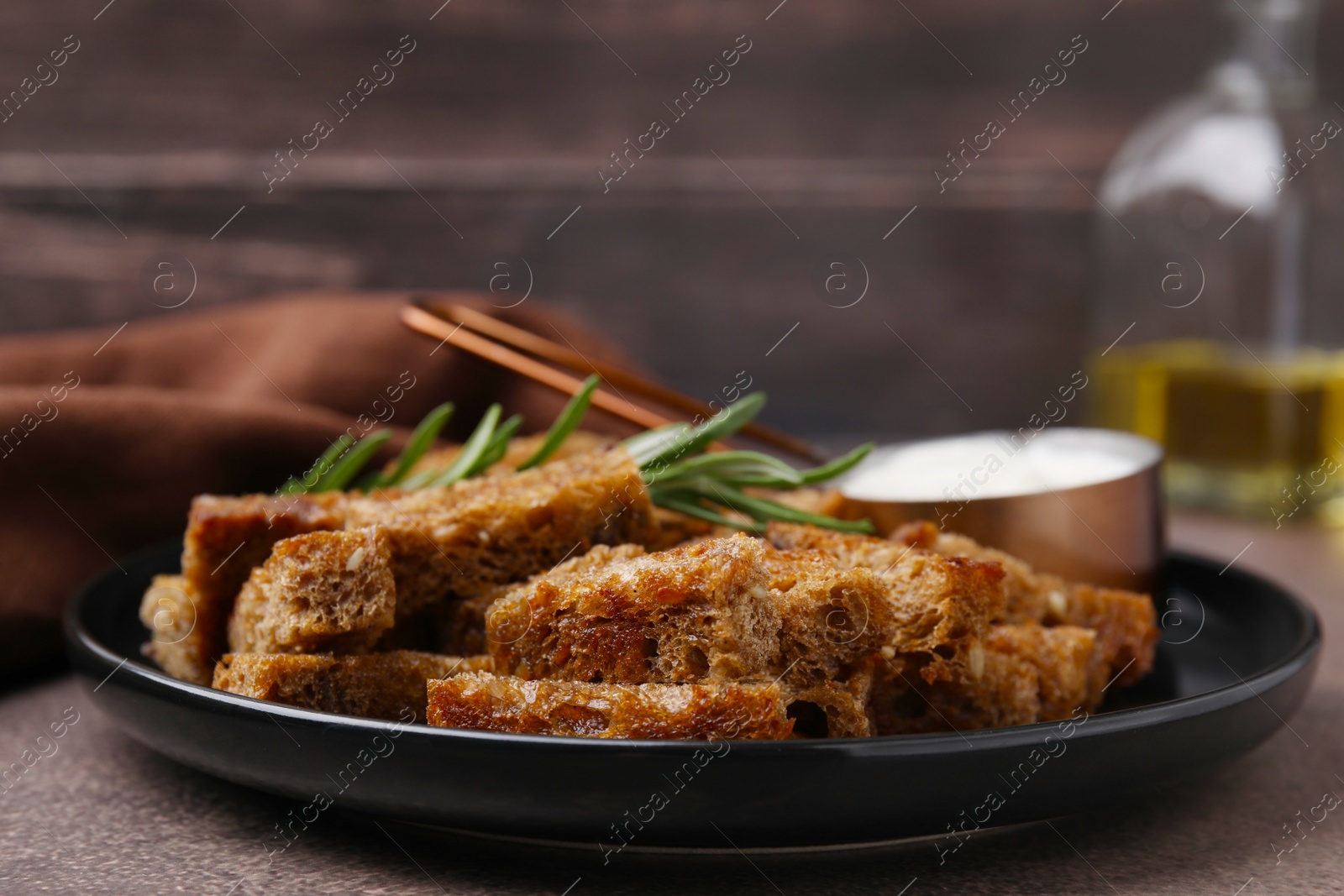 Photo of Crispy rusks with rosemary and sauce on grey table