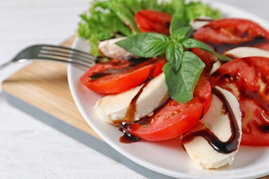 Photo of Plate with delicious fresh salad on table, closeup