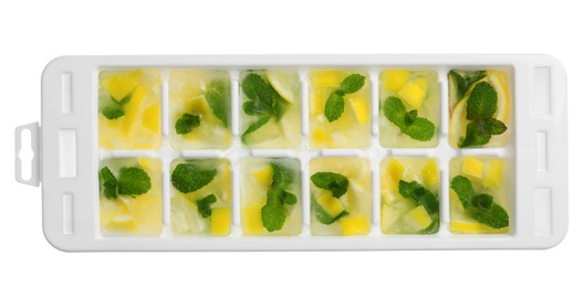 Photo of Ice cubes with lemon and mint in tray on white background, top view