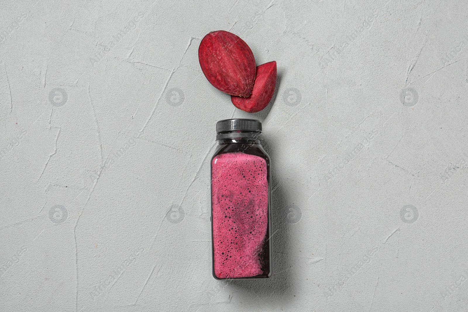 Photo of Bottle of beet smoothie on light background, top view