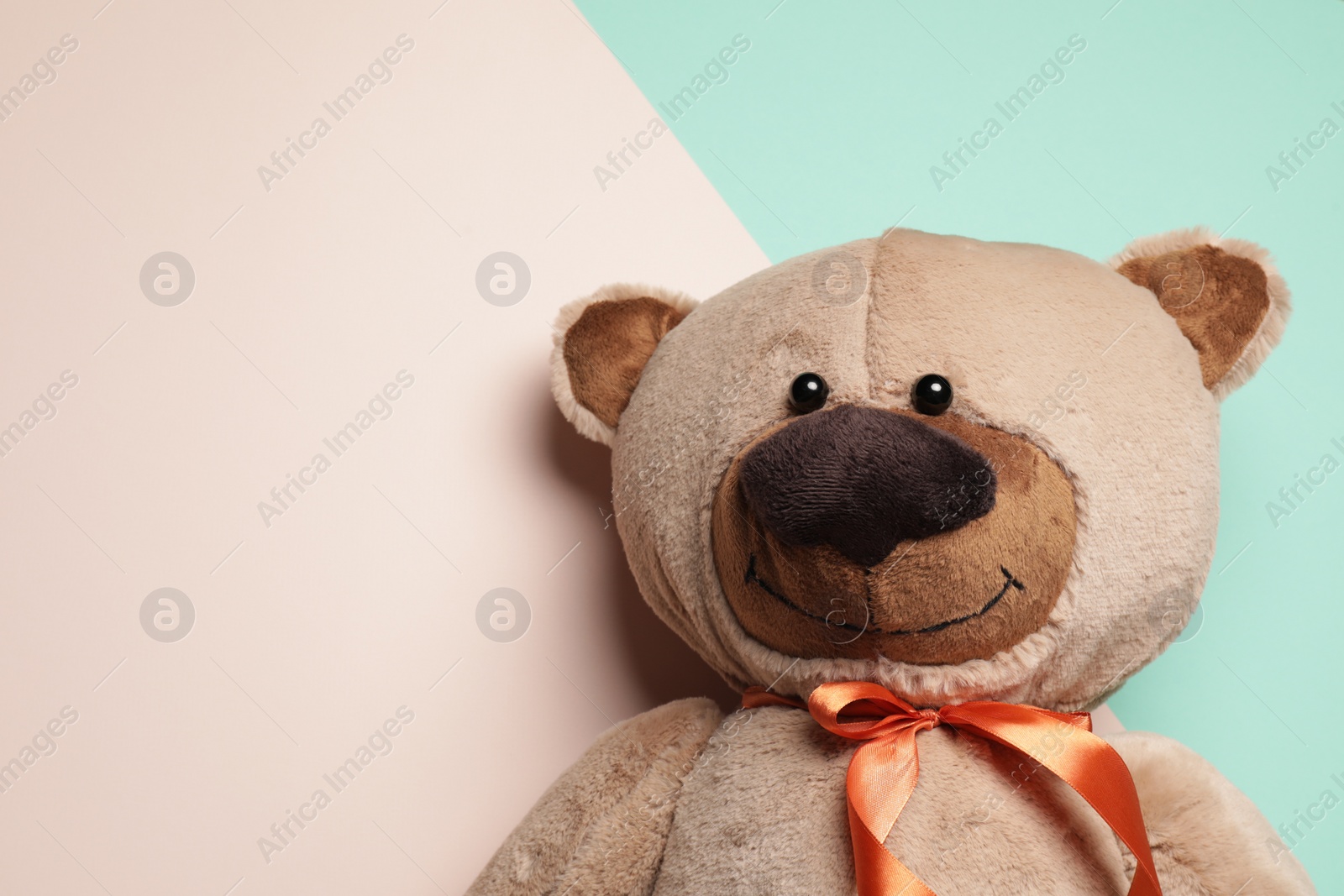 Photo of Cute teddy bear on color background, top view. Space for text