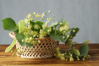 Photo of Fresh linden leaves and flowers on wooden table