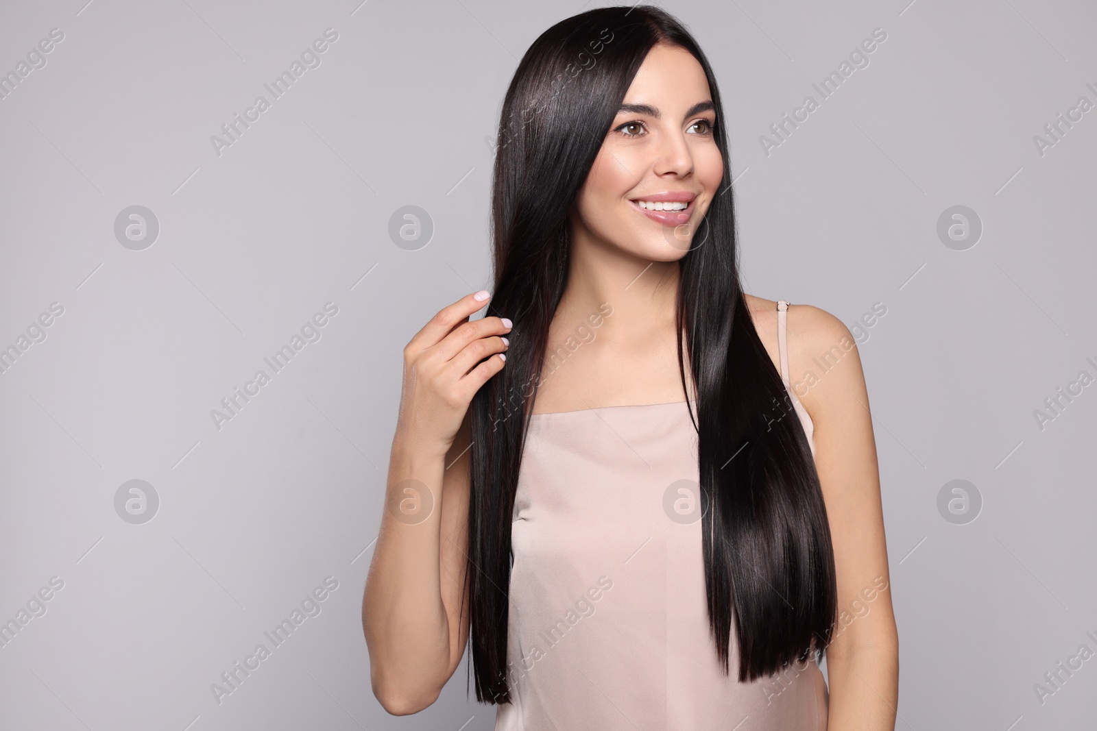 Photo of Portrait of beautiful young woman with healthy strong hair on light grey background, space for text