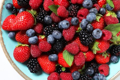 Photo of Many different fresh ripe berries in bowl on white table, top view