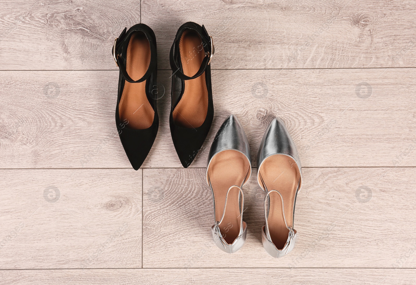 Photo of Different female shoes on wooden background, top view