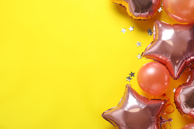 Photo of Colorful balloons and confetti on yellow background, flat lay. Space for text