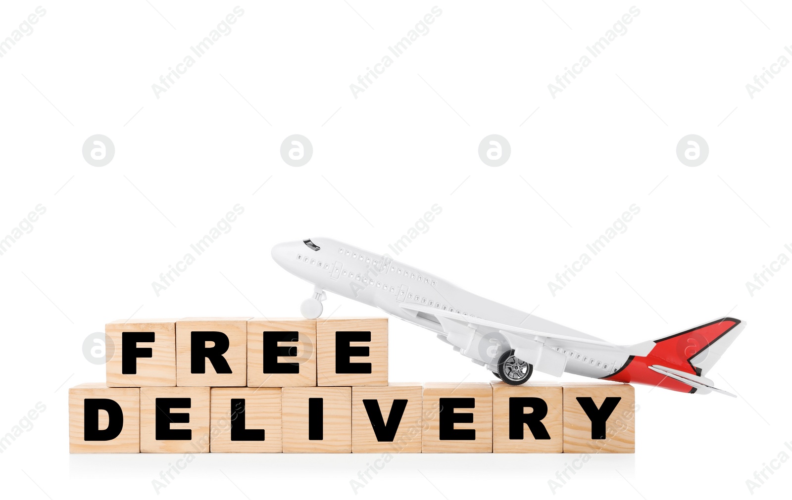 Photo of Toy plane and cubes with words FREE DELIVERY isolated on white. Logistics and wholesale concept