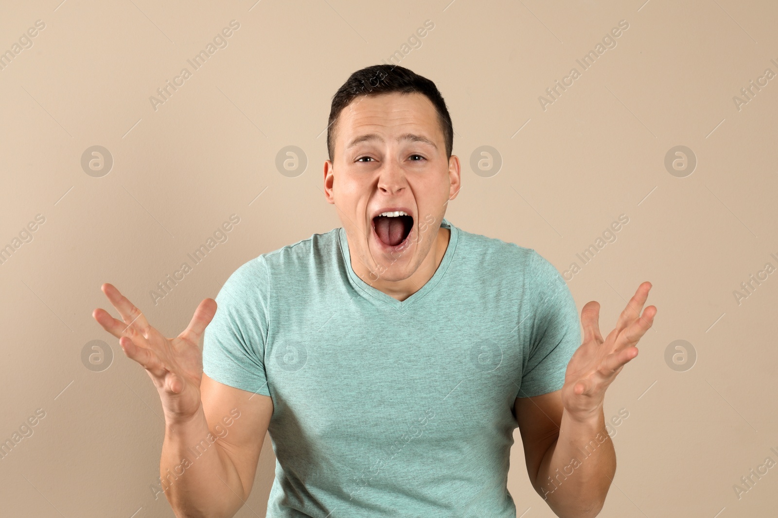 Photo of Confident handsome young man on beige background