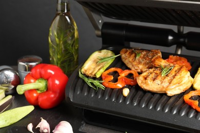 Photo of Electric grill with different products on grey table