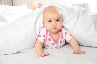 Cute baby girl in bed at home. Bedtime schedule