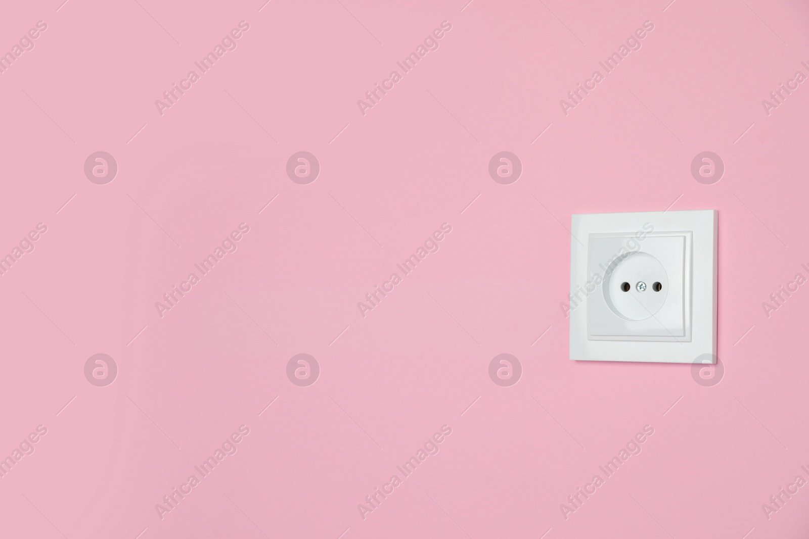 Photo of Power socket on pink wall, space for text. Electrical supply