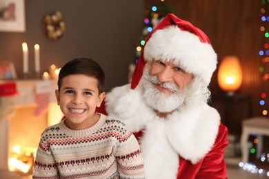 Photo of Portrait of little child with Santa Claus at home. Christmas celebration