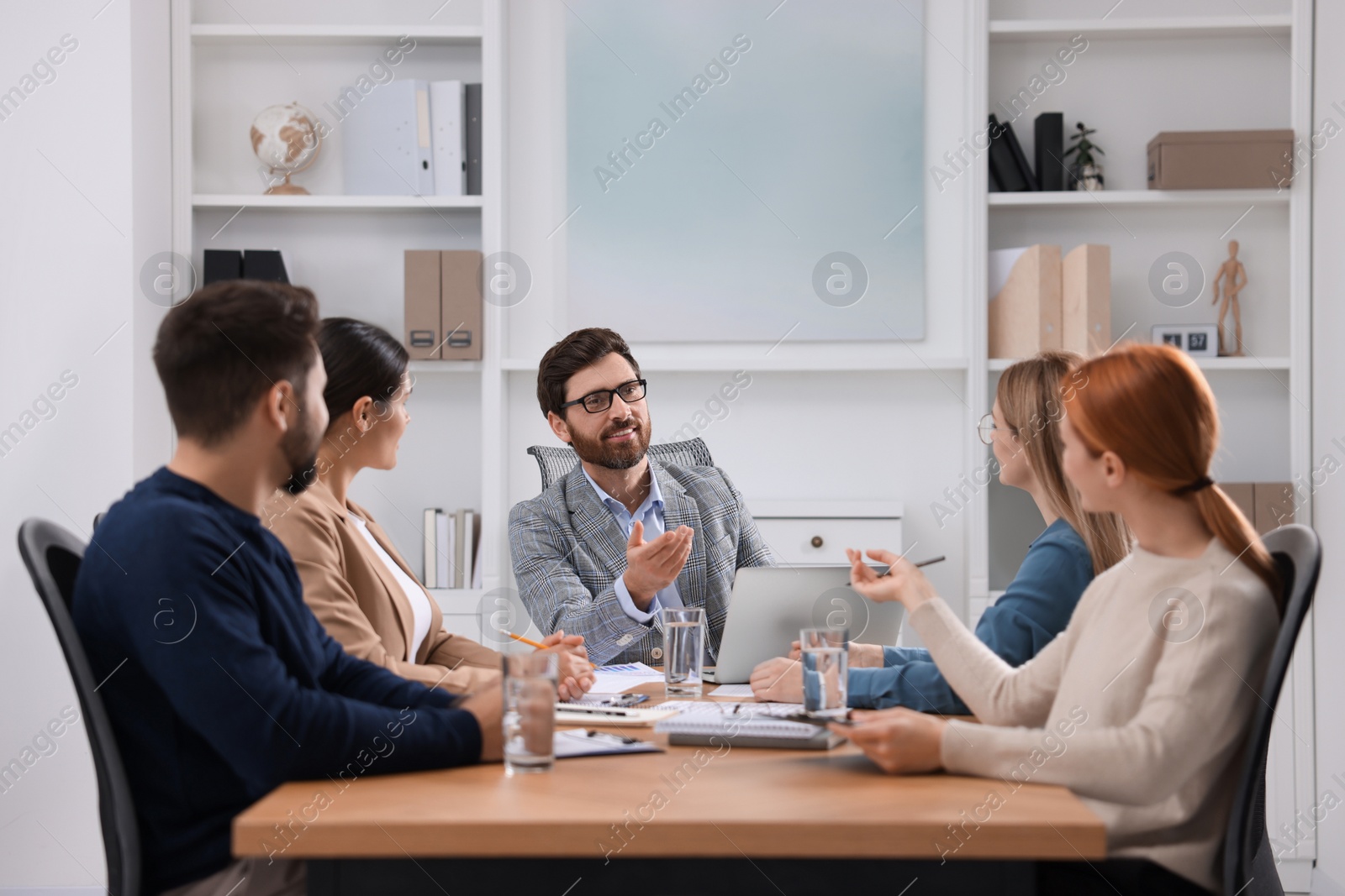 Photo of Team of employees working together in office