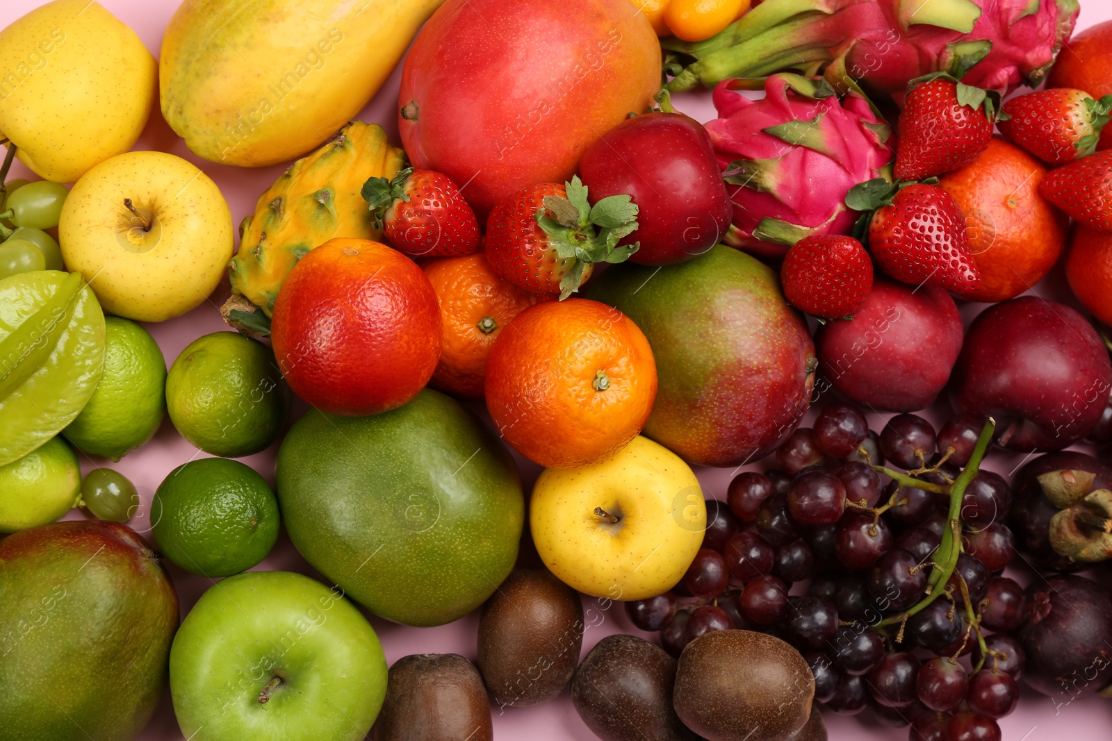 Photo of Assortment of fresh exotic fruits on pink background, top view