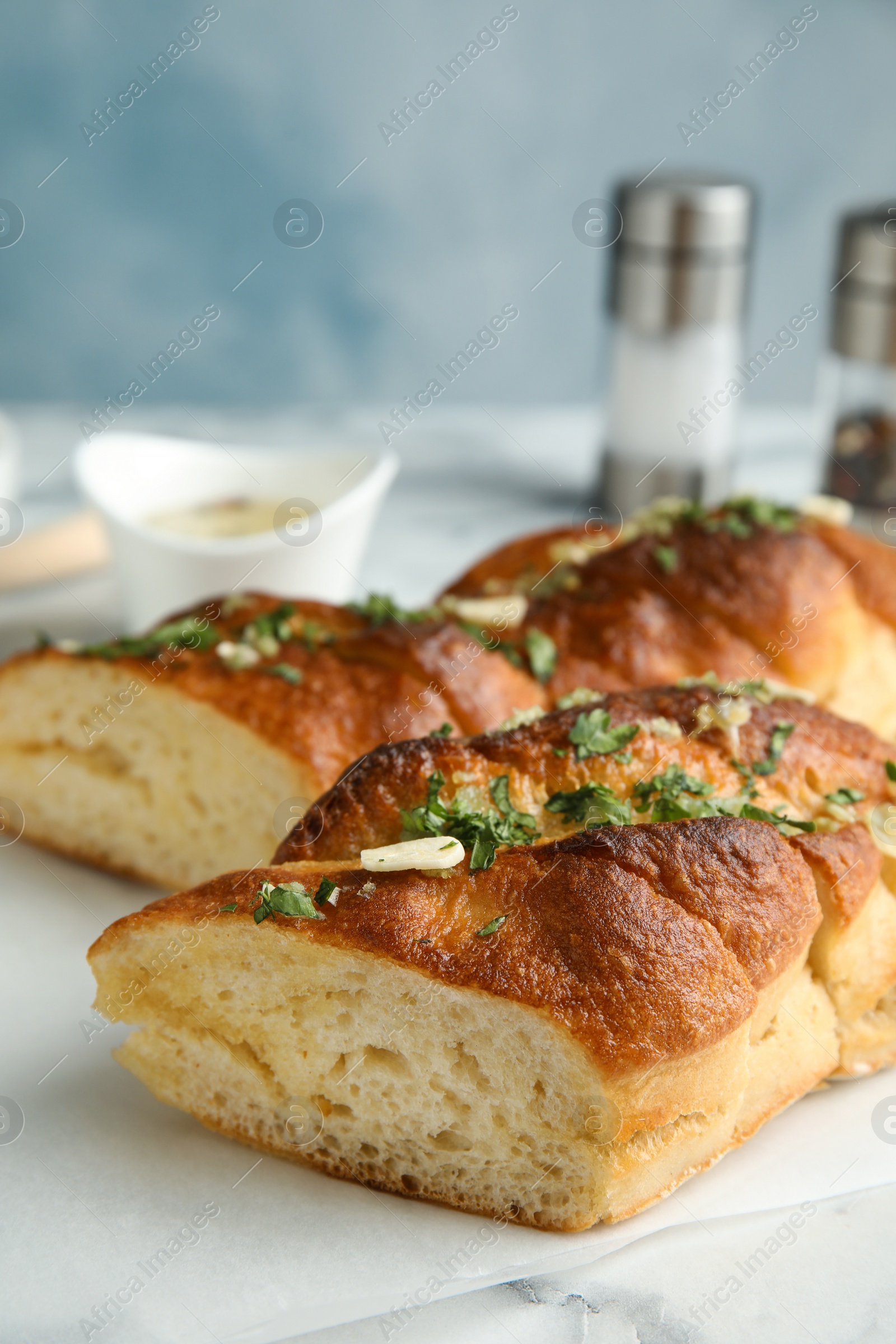 Photo of Delicious homemade garlic bread with herbs on table