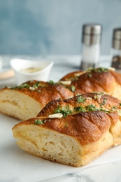 Photo of Delicious homemade garlic bread with herbs on table