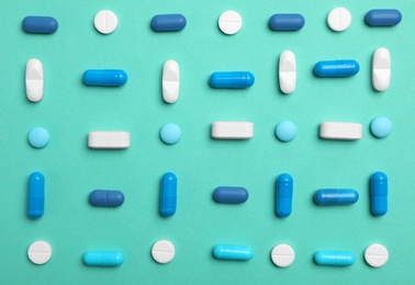 Photo of Different pills and capsules on color background, flat lay