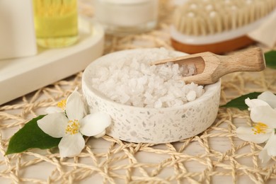 Photo of Sea salt in bowl and beautiful jasmine flowers on white table