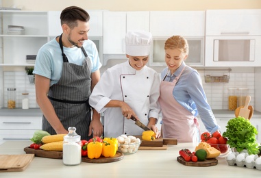 Photo of Group of people and female chef at cooking classes