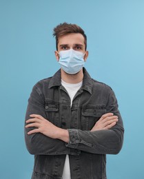 Photo of Portrait of man with medical mask on light blue background