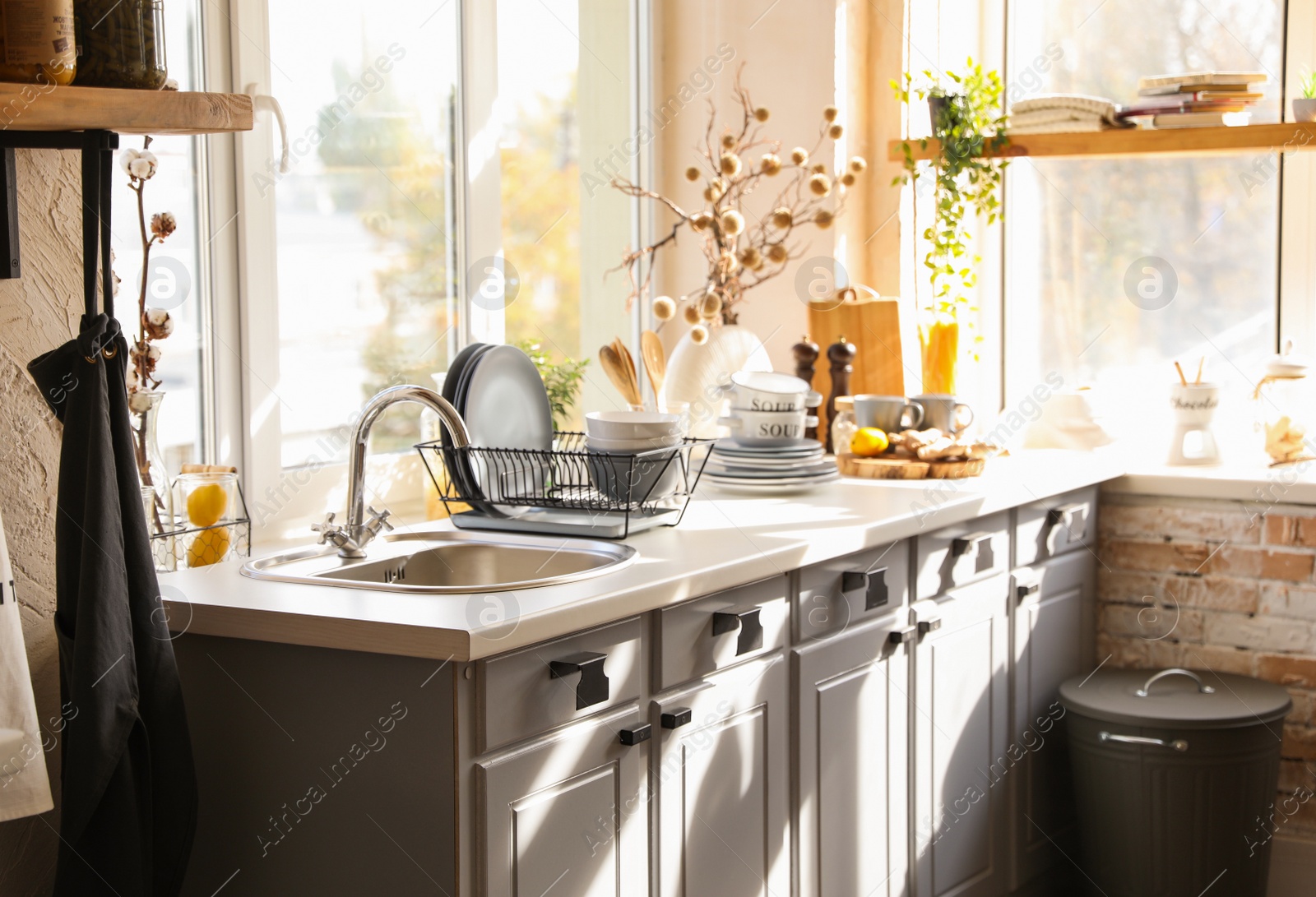 Photo of Stylish kitchen with sink and clean dishware