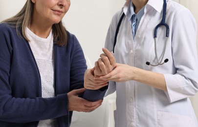 Arthritis symptoms. Doctor examining patient's wrist in hospital