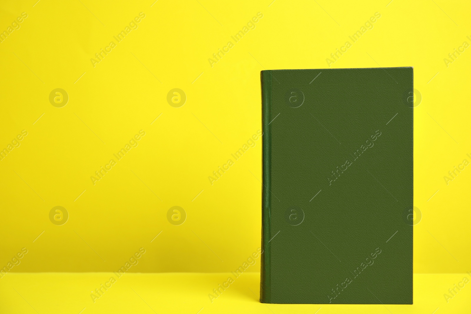 Photo of Hardcover book on yellow background. Space for design