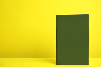 Photo of Hardcover book on yellow background. Space for design