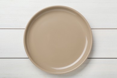 Photo of Empty ceramic plate on white wooden table, top view