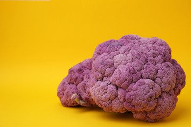 Photo of Fresh purple cauliflowers on yellow background. Space for text