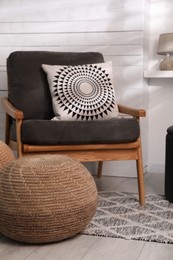 Photo of Stylish comfortable pouf near armchair in room. Home design