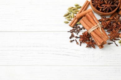 Flat lay composition with mulled wine ingredients on white wooden table. Space for text