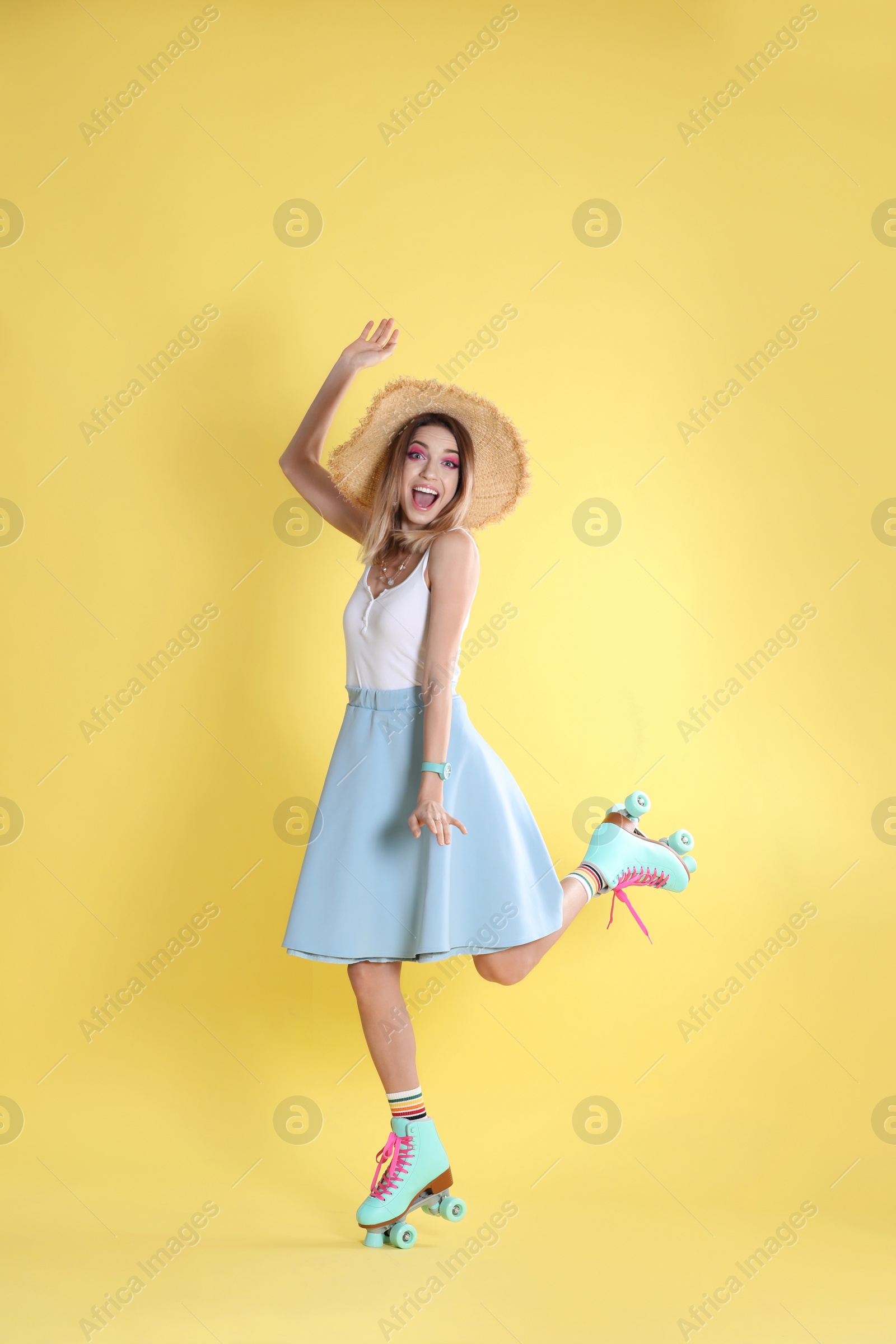 Photo of Young woman with retro roller skates on color background