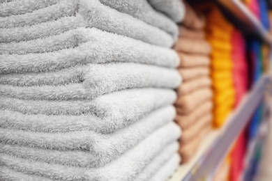 Stacks of colourful towels on store shelf, closeup