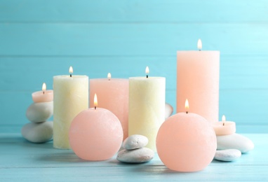 Photo of Composition of burning candles and spa stones on table