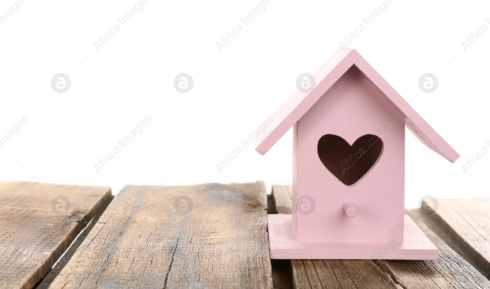 Photo of Beautiful bird house with heart shaped hole on wooden table against white background, space for text
