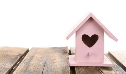 Beautiful bird house with heart shaped hole on wooden table against white background, space for text