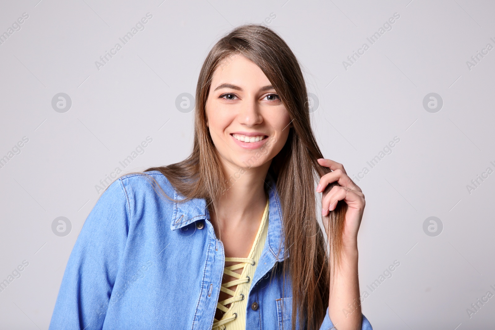 Photo of Portrait of young woman with long beautiful hair on light background