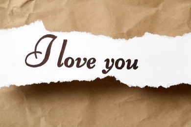 Photo of Torn sheet of paper with text I Love You on crumpled beige background, top view