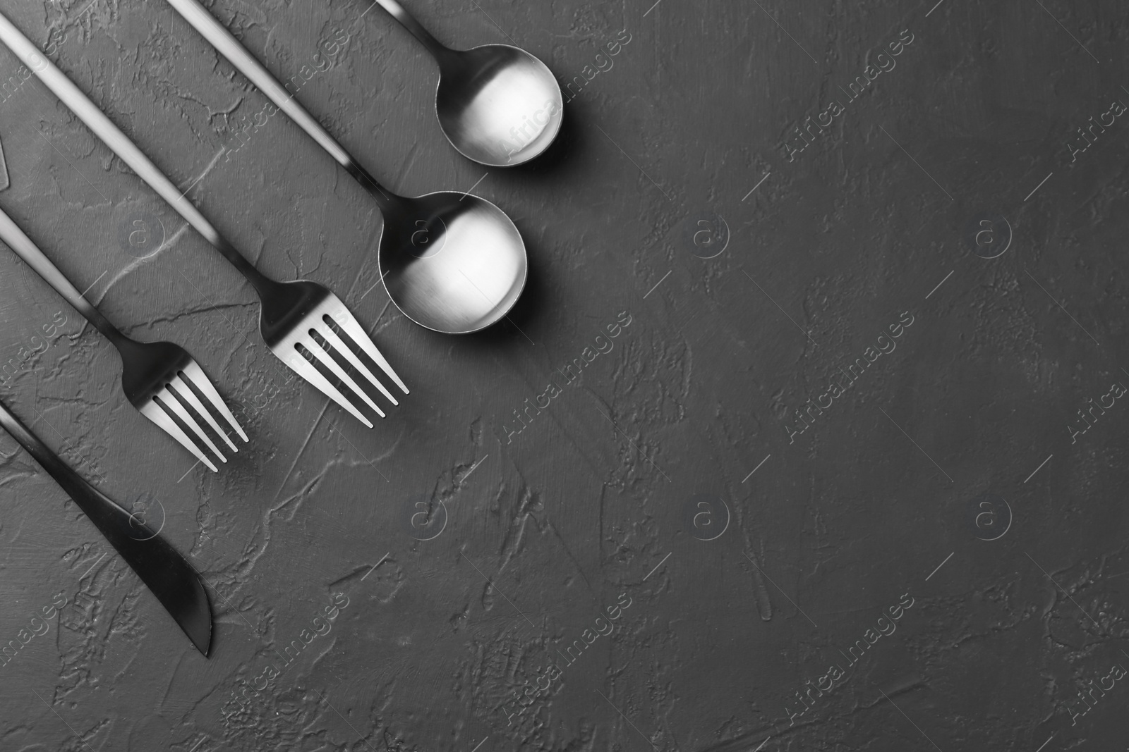 Photo of Beautiful cutlery set on black table, flat lay. Space for text