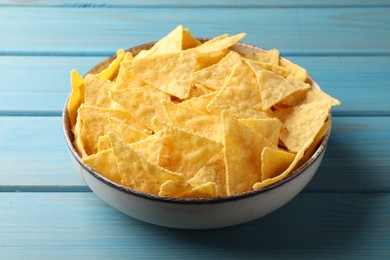 Photo of Tortilla chips (nachos) in bowl on light blue wooden table