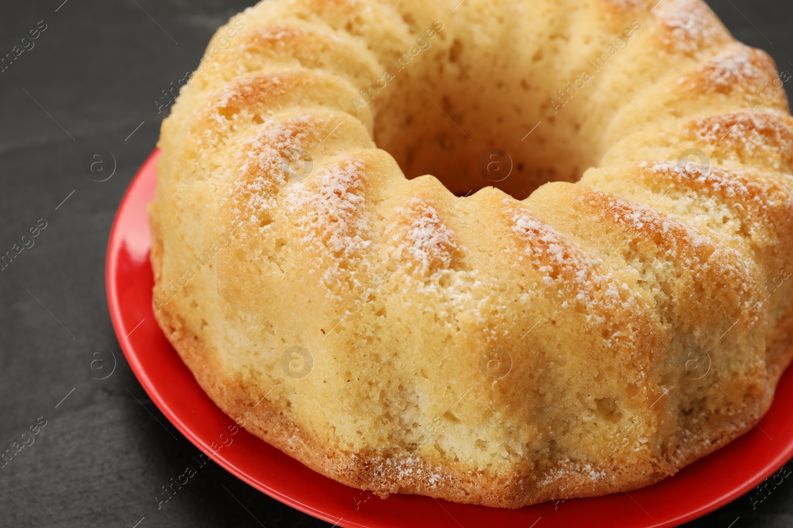 Photo of Delicious freshly baked sponge cake on black table, closeup